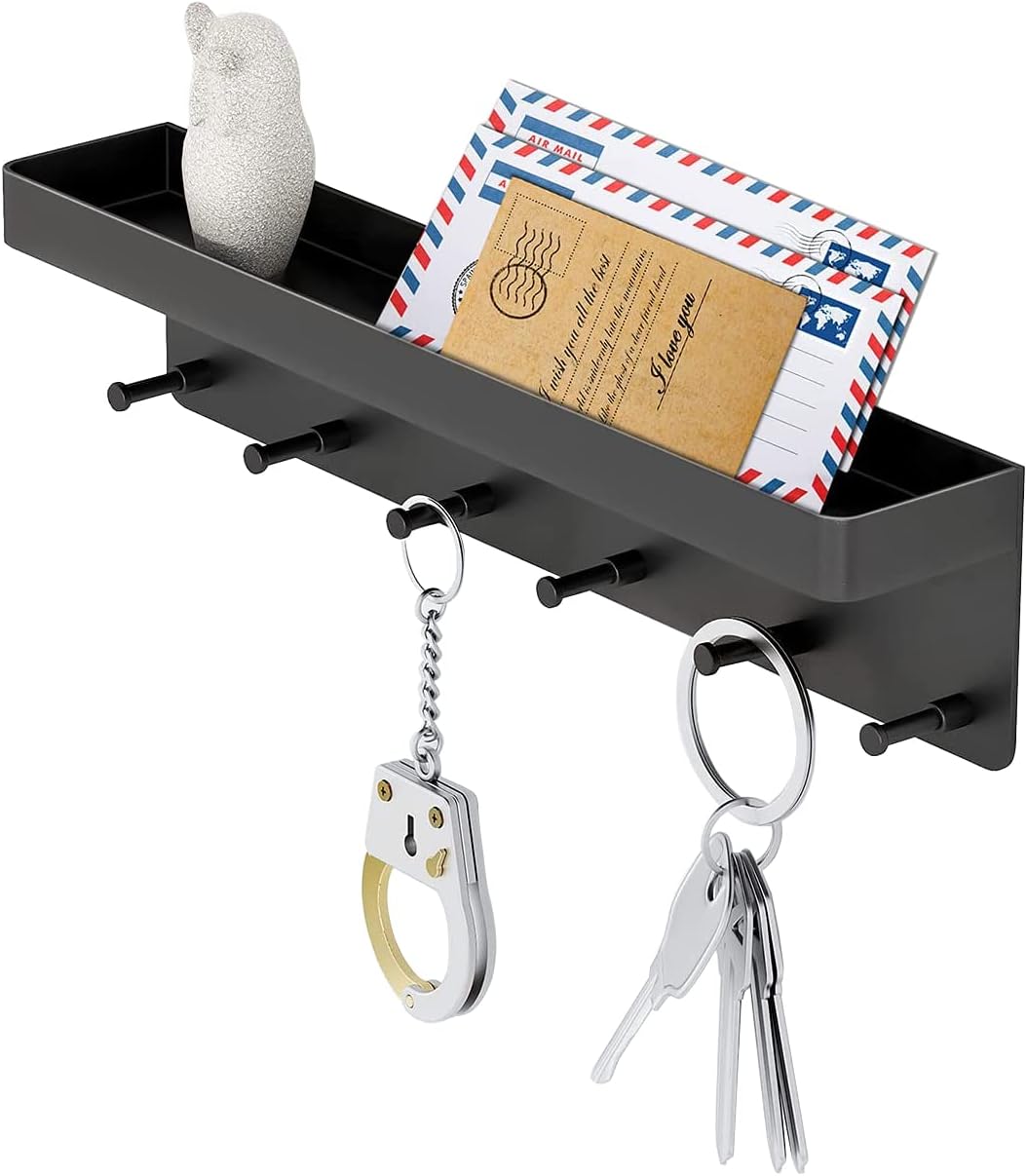 Black adhesive key holder with six hooks and a mail tray mounted by an entry door
